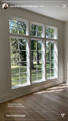 an empty room with large windows and wood flooring on the side of the wall