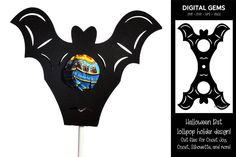 a black bat shaped cake topper on a stick with an image of a bus