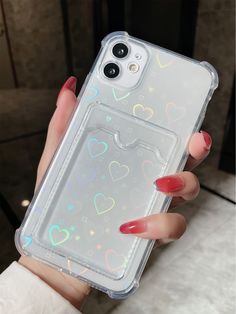 a woman's hand holding an iphone case with hearts on it