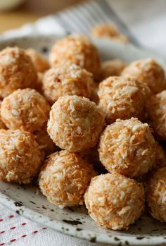 a white plate filled with coconut balls on top of a table