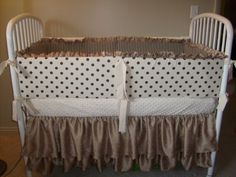 a white crib with brown ruffles and polka dots