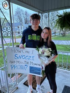 a man and woman standing next to each other holding a sign that says how can i snooze and miss the moment?