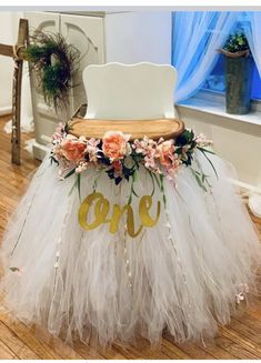 a tulle skirt with flowers and the word care on it is sitting in front of a window