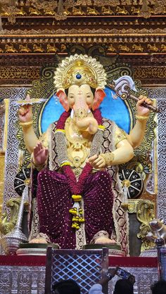 the statue of lord ganesh is displayed in front of people