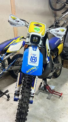 a blue and yellow dirt bike parked in a garage