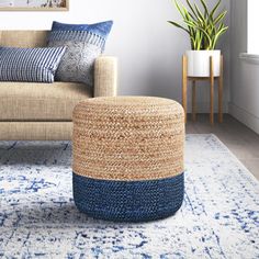 a living room with a couch, chair and rug on the floor in front of a window