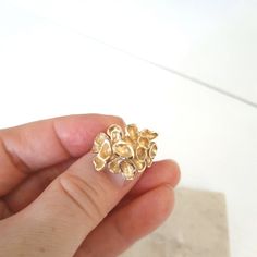 This is an absolutely amazing fancy statement gold ring. The ring is custom made and has a romantic touch into it. It is made of 10k solid yellow gold and weighs 5.5 grams. The size is 4.5 US. The ring features a gorgeous looking tropical flower where each petal is artistically crafted and different. The ends of each petal have a diamond cut, which makes the ring shine. The top of the ring measures 0.8 inches. The ring has a '10k' gold hallmark. The ring will definitely make a beautiful gift for any special occasion. The ring comes in a jewelry box and with a 'Thank you' card. If you are not satisfied with a ring, I will gladly accept a return. Contact me within 3 days of delivery and dispatch the item back within the next 3 work days. For more jewelry in my store visit: https://www.etsy.c Fine Jewelry Brass Rings For Anniversary, Unique Recycled Gold Jewelry For Anniversary, Elegant Yellow Gold Nugget Rings, Unique Wedding Jewelry In Recycled Gold, Wedding Jewelry In Recycled Gold, Unique Recycled Gold Wedding Jewelry, Yellow Gold Brass Rings For Anniversary, Formal Gold Flower Ring Stamped 14k, Heirloom Style Gold Cluster Ring