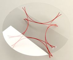 a round glass table with red wire on it and a white paper underneath the plate