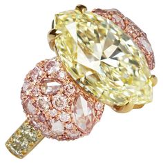 Introducing a one-of-a-kind ring in 18K Yellow & Rose gold with a stunning GIA Certified Fancy Light Yellow 6.02 ct. Marquise shape diamond centerstone. The centerstone is surrounded by a beautiful array of pave set Fancy Pink brilliant-cut diamonds, Fancy Pink rose-cut diamonds, and Fancy Green brilliant-cut diamonds, creating a harmonious color palette that is both striking and understated. To effectively communicate the protective design of the ring's setting for the marquise cut diamond, you Cocktail Ring Designs, Antique Cocktail Ring, Pink Halo, Sapphire Cocktail Ring, Antique Diamond Engagement Rings, Fancy Light, Marquise Shape Diamond, Fancy Lights, Diamond Cocktail Ring