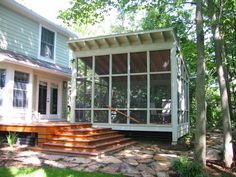 a screened in porch with steps leading up to it