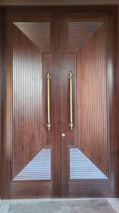 two wooden doors with gold handles and sidelights on the front of a house,