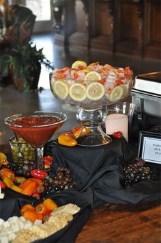 an assortment of fruit and vegetables on a table with a bowl of dips in the middle