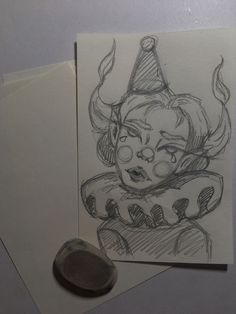 a drawing of a clown on paper next to a waxed stamp with a penny