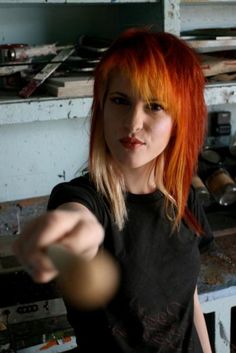 a woman with red hair pointing at something