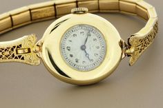 This wrist watch is by Agassiz Watch Co and the Wittnauer and Co. The case of the watch is down in 18K gold, is marked 2006, and the back of the case is engraved with a faint "AMB". The movement is Swiss, 18 jewel, and is marked 1365. The dial of the watch is engraved and enameled. The bracelet is 12K gold filled and is a stretch.The watch case measures 23.24mm wide, 26mm long, and sits 6.77mm tall.--Please reference our policy for more details--***For International orders, please provide a phon Antique Yellow Gold Watch Accessories With Subdials, Victorian Gold Watch With Chronometer, Victorian Style Gold Watch With Chronometer, Antique Yellow Gold Watch Accessories For Formal Events, Victorian Yellow Gold Watches For Anniversary, Victorian Yellow Gold Anniversary Watch, Victorian Yellow Gold Formal Watches, Vintage Yellow Gold Chronometer Jewelry And Watches, Antique Yellow Gold Watch With Round Dial