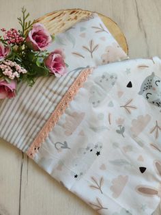 two baby swaddles with pink flowers on them and one has an owl in it