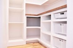 an empty closet with white shelves and bins