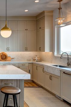 a kitchen with an island and stools in it