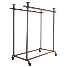 a metal rack with three candles on it and four wheels attached to the top one