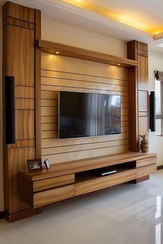 a living room with a large tv mounted on the wall and wooden paneling around it