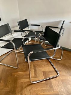 four black chairs sitting on top of a hard wood floor