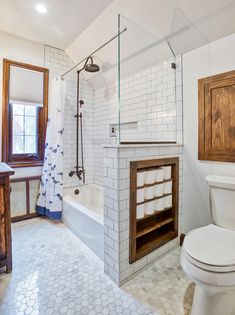 a bathroom with a toilet, sink and bathtub next to a window in it