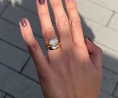 a woman's hand with a ring on it and a manicured nail polish