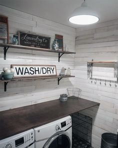 a washer and dryer in a small room with shelves on the wall above them