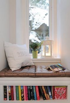 a window sill filled with books next to a window