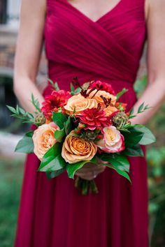 a woman in a red dress holding a bouquet of flowers