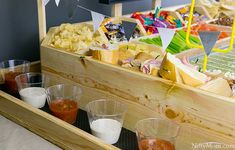 an assortment of food on display in wooden trays