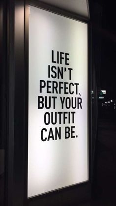 a sign on the side of a building that says life isn't perfect but your outfit can be