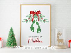 a christmas card with a red bow and mistlet on it next to small trees