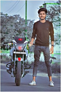 a man standing next to a motorcycle on the street