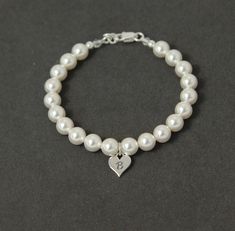 "This dainty pearl and Sterling Silver initial bracelet makes the perfect gift for your bridesmaid and coordinates well with my initial bracelets and necklaces (https://www.etsy.com/shop/SprigJewelry?ref=hdr_shop_menu&search_query=silver+initial+pearl). An elegant heart with the initial of your choice in Sterling Silver is surrounded by Swarovski crystal pearls. The silver heart measures approximately 8mm across, with a 6mm pearl. Please select the initial and length you would like from the Silver Initial Bracelet, Sterling Silver Flower Bracelet, Initial Bracelet Silver, Initial Bracelets, Bridesmaid Bracelet Gift, Flower Girl Jewelry, Flower Girl Bracelets, Mothers Bracelet, Bridesmaid Pearls