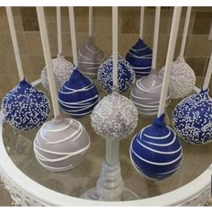 there are many blue and white candies on the glass table with candlesticks