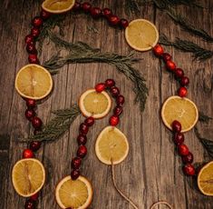 orange slices and cranberries are arranged on a wooden table