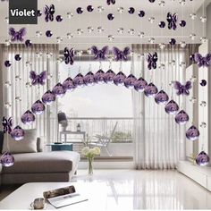 the living room is decorated in purple and white colors with crystal balls hanging from the ceiling