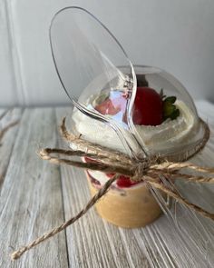 a jar filled with food sitting on top of a white wooden table next to a string