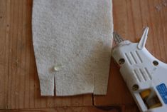 a pair of scissors next to a piece of fabric on a wooden table with a hole in it