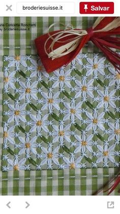 a green and white checkered table cloth with red tassels on top of it