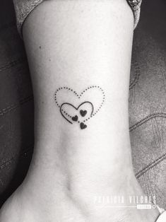 a small heart tattoo on the ankle with two hearts in it and an arrow at the bottom