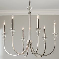 a chandelier with six lights hanging from it's sides in a room