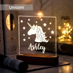 a light up unicorn with stars and the word'ashley'in white on it