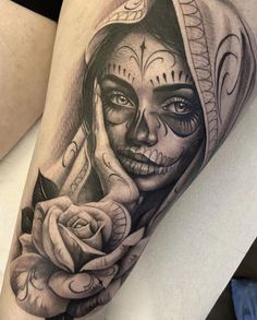 a woman's leg with a tattoo on it and a rose in her hand