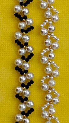 two necklaces with black and white beads on them, one is made out of plastic