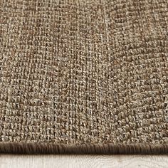 a close up view of a brown rug on a wooden floor