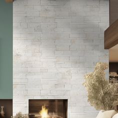 a living room filled with furniture and a fire place in front of a white brick wall