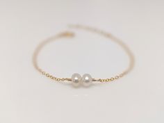 "Our gift to you 10% off your first purchase. Details here - http:/eepurl.com/dpVPBz You have found the perfect dainty pearl bracelet. Available with 1, 2 or 3 pearls. Personalize the number of pearls with your wishes, goals, children etc. Perfect for that special occasion yet simple enough for every day wear. You and your loved one will adore this meaningful gift. DETAILS 14 k fill or Sterling Silver. Choose 1, 2 or 3 pearls. Each fresh water pearl is unique, meaning the size and shape may vary Minimalist Pearl Bangle Jewelry, Dainty Pearl Drop Bracelet, Dainty Pearl Drop Jewelry, Pearl White Bracelets With Pearl Charm For Bridesmaids, Pearl Drop Bangle Bracelet For Gift, Minimalist Pearl Bangle Bracelet Gift, Pearl Chain Bracelet As Gift, Pearl White Bracelet Jewelry As Bridesmaid Gift, Adjustable Pearl Drop Bracelet For Bridesmaids