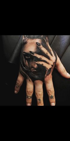 a person's hand with tattoos on it